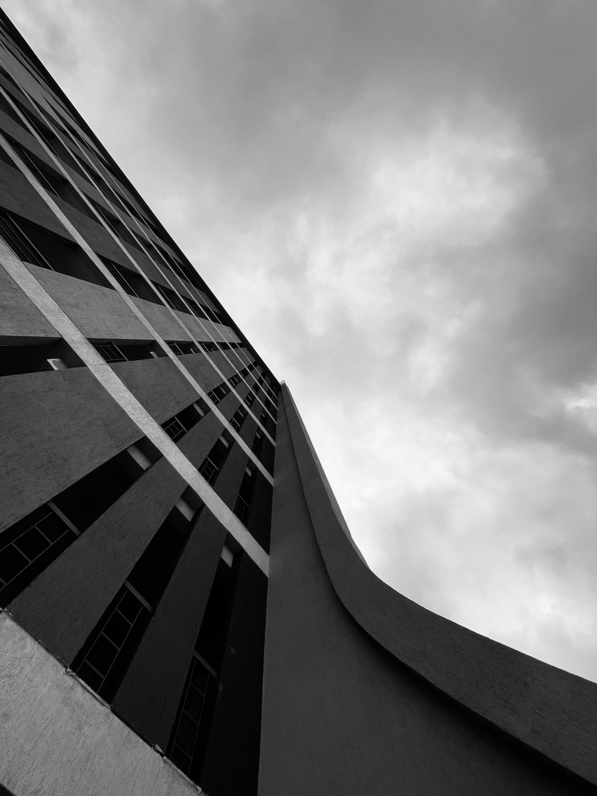 Black and white view of a contemporary building facade in Pune against a cloudy sky