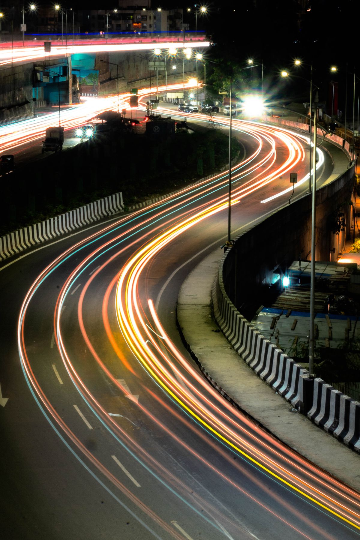 Light trails from traffic on a curving road in Bavdhan, Pune, at night